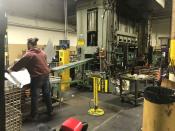 An operator transferrs steel shelf after being stamped out in punch press at Tennsco's factory in Dickson