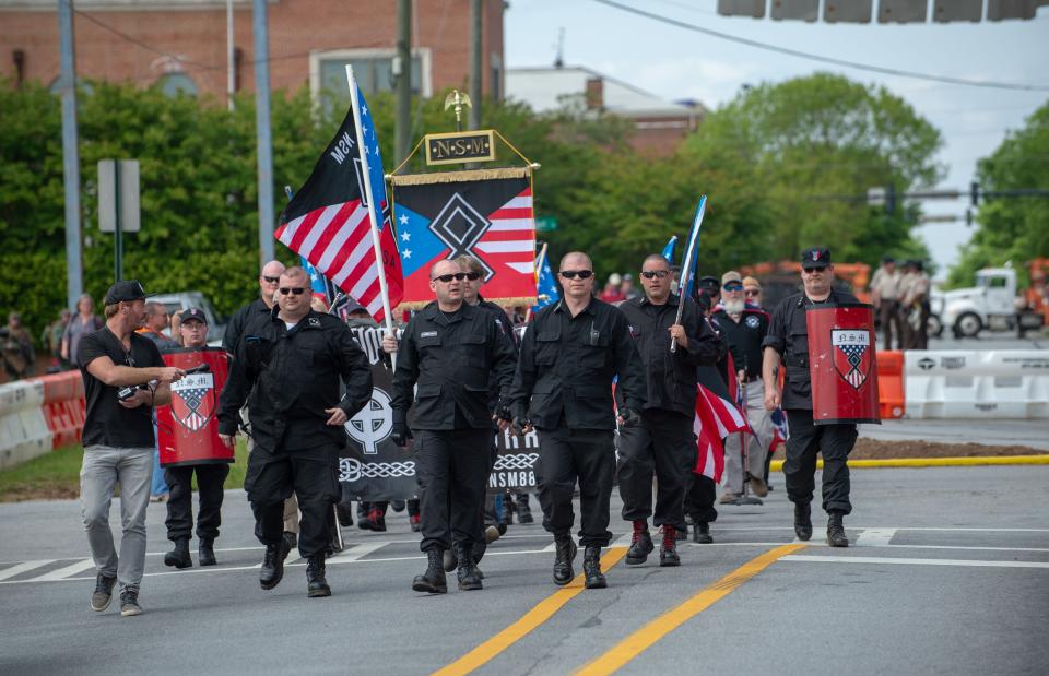 Members of the National Socialist Movement (NSM) and other white nationalists march toward the entrance to Greenville Street Park in Newnan, Georgia on April 21, 2018. Only about 25 NSM and white nationalists turned up for the rally in the park, while counter-protesters showed up in the hundreds.