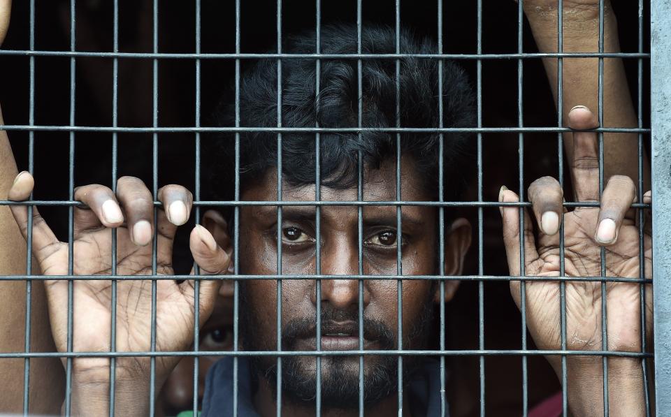 Bangladeshi migrant Jahangir Hussain looks out of a police van at the Police headquarters in Langkawi on May 11, 2015 after landing on Malaysian shores earlier in the day. (MANAN VATSYAYANA/AFP/Getty Images)