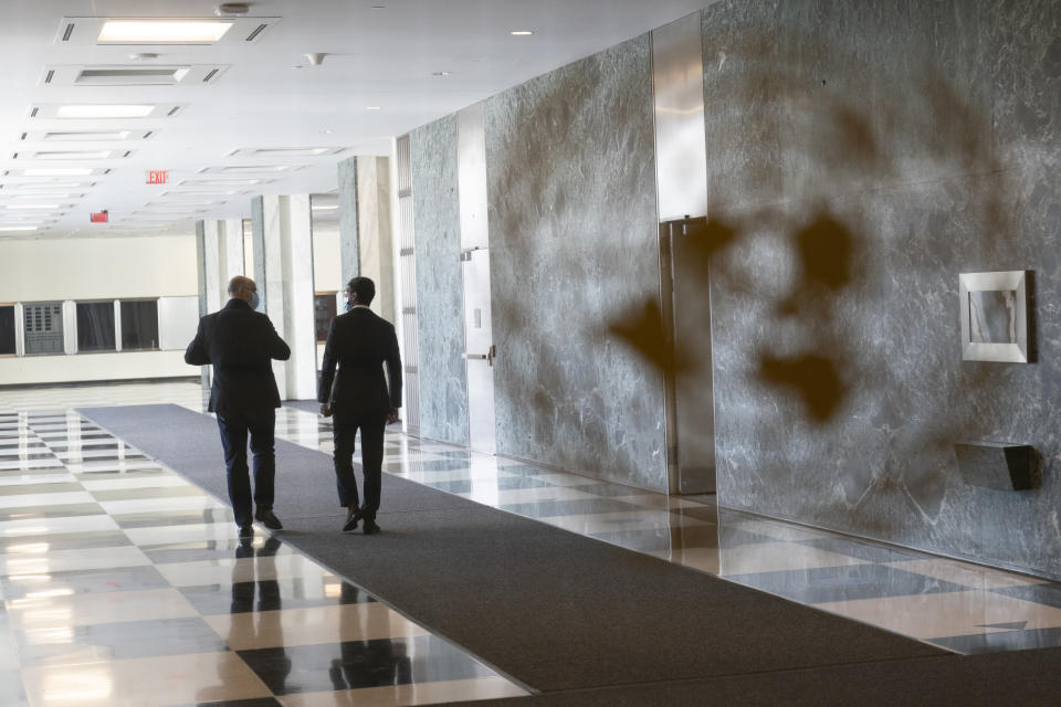 A couple of delegates walk in the hallway of the Secretariat building during the 75th session of the United Nations General Assembly, Tuesday, Sept. 22, 2020, at U.N. headquarters. This year's annual gathering of world leaders at U.N. headquarters will be almost entirely "virtual." Leaders have been asked to pre-record their speeches, which will be shown in the General Assembly chamber, where each of the 193 U.N. member nations are allowed to have one diplomat present. (AP Photo/Mary Altaffer)