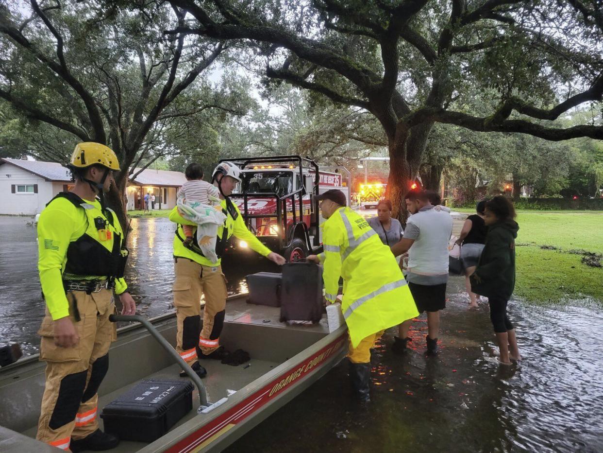 In this photo provided by Orange County Fire Rescue's Public Information Office, firefighters in Orange County, Fla. help people stranded by Hurricane Ian early Thursday, Sept. 29, 2022.