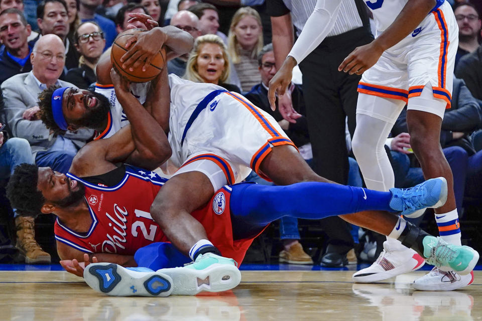 Philadelphia 76ers' Joel Embiid (21) fights for control of the ball with New York Knicks' Mitchell Robinson (23) during the first half of an NBA basketball game Tuesday, Oct. 26, 2021, in New York. (AP Photo/Frank Franklin II)