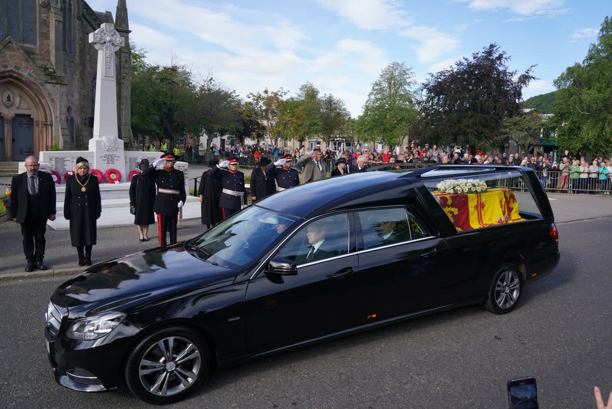 Members of the military salute the hearse carrying the coffin of Queen Elizabeth II (PA) (PA Wire)