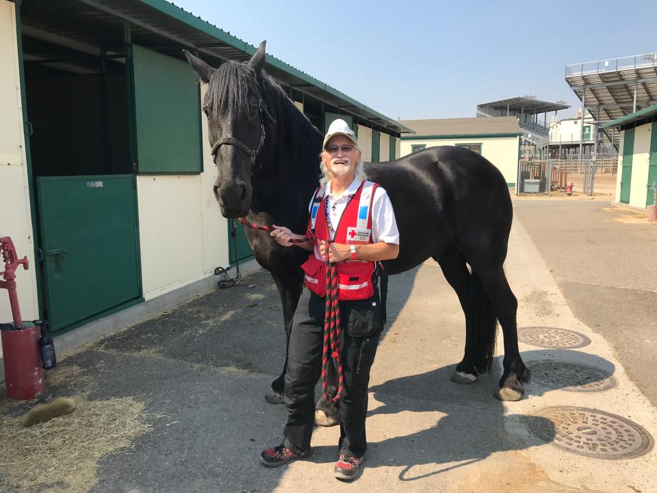 Walter Roberts Jr. stands with a horse at an animal shelter in Reno, Nev., onn the western side of the Caldor Fire this summer in California-Nevada Sierra Nevada Range.