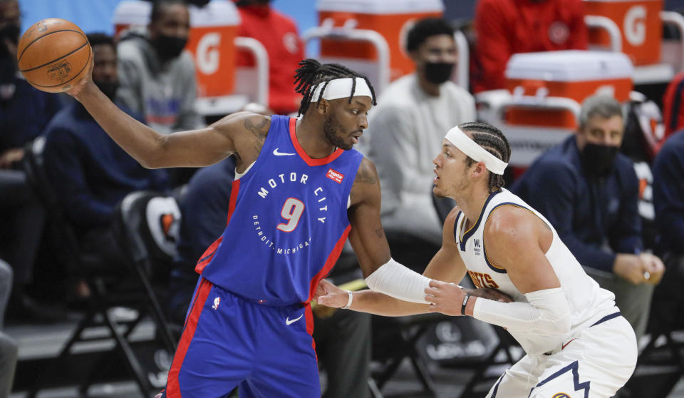 Detroit Pistons forward Jerami Grant (9) holds the ball away from Denver Nuggets forward Aaron Gordon (50) in the first quarter of an NBA basketball game in Denver, Tuesday, April 6, 2021. (AP Photo/Joe Mahoney)