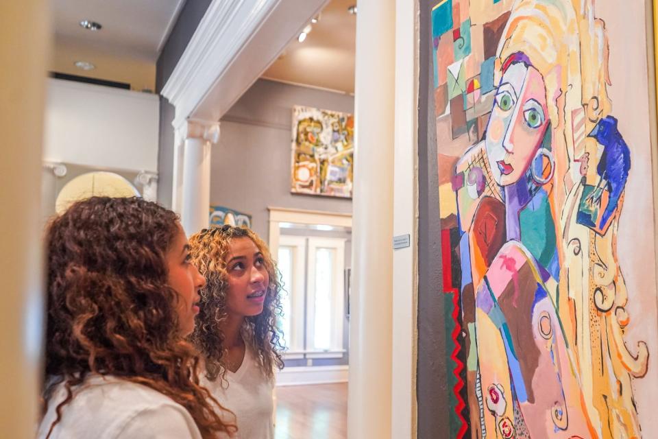 Women look at art on display