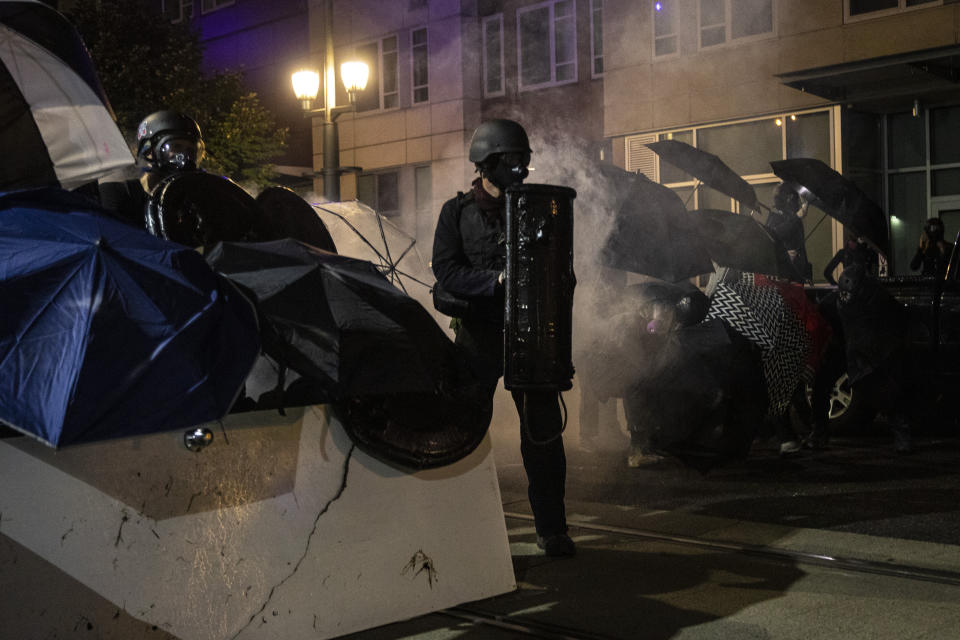 Protesters stand off with police during protests Friday, Sept. 18, 2020, in Portland, Ore. The protests, which began over the killing of George Floyd, often result frequent clashes between protesters and law enforcement. (AP Photo/Paula Bronstein)