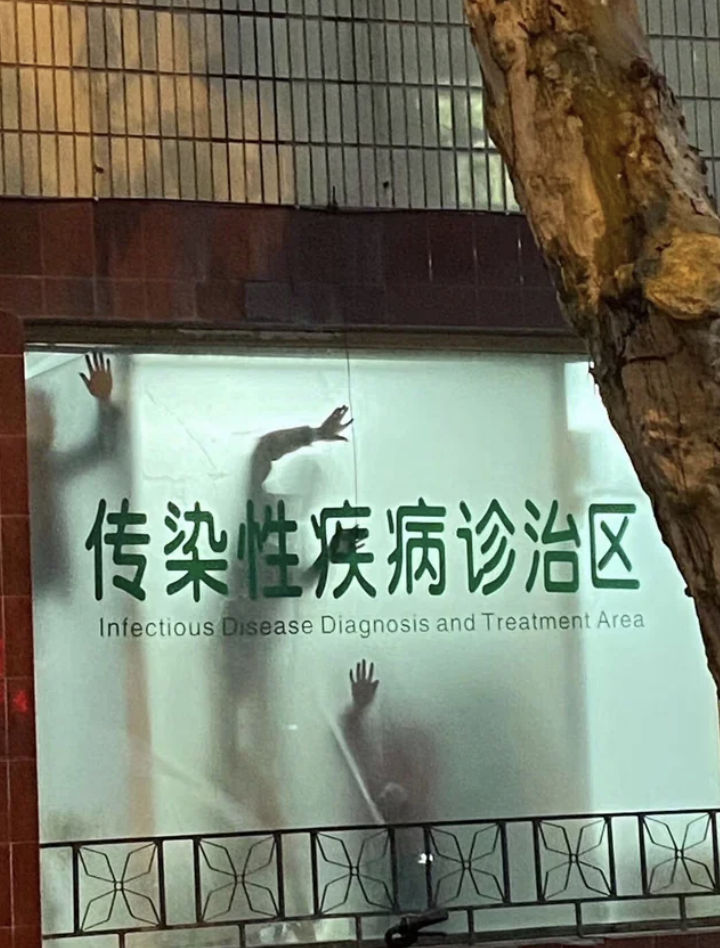 Silhouettes of people behind a fogged window of the “Diagnosis and Treatment of Infectious Diseases” department, seen from outside the building