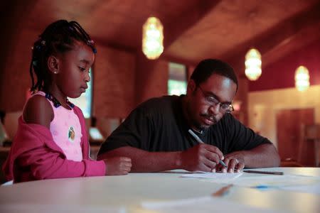 Skylar Middlebrows, 6, looks on as her father, Stephen Middlebrows fills out a voter certificate before voting for Georgia's 6th Congressional District special election at St. Bede's Episcopal Church in Tucker, Georgia, U.S., June 20, 2017. REUTERS/Chris Aluka Berry