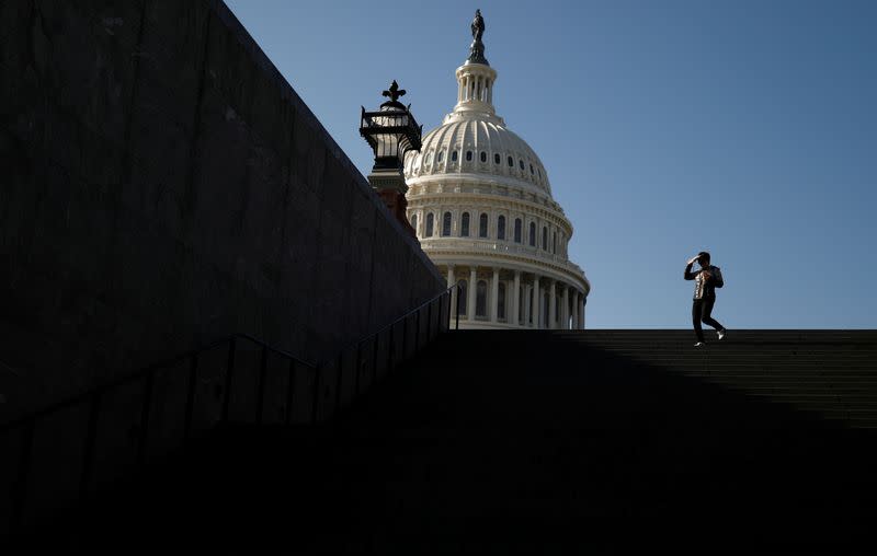 A visitor walks outside of the U.S. Capitol before an expected House vote on appointing impeachment managers in Washington