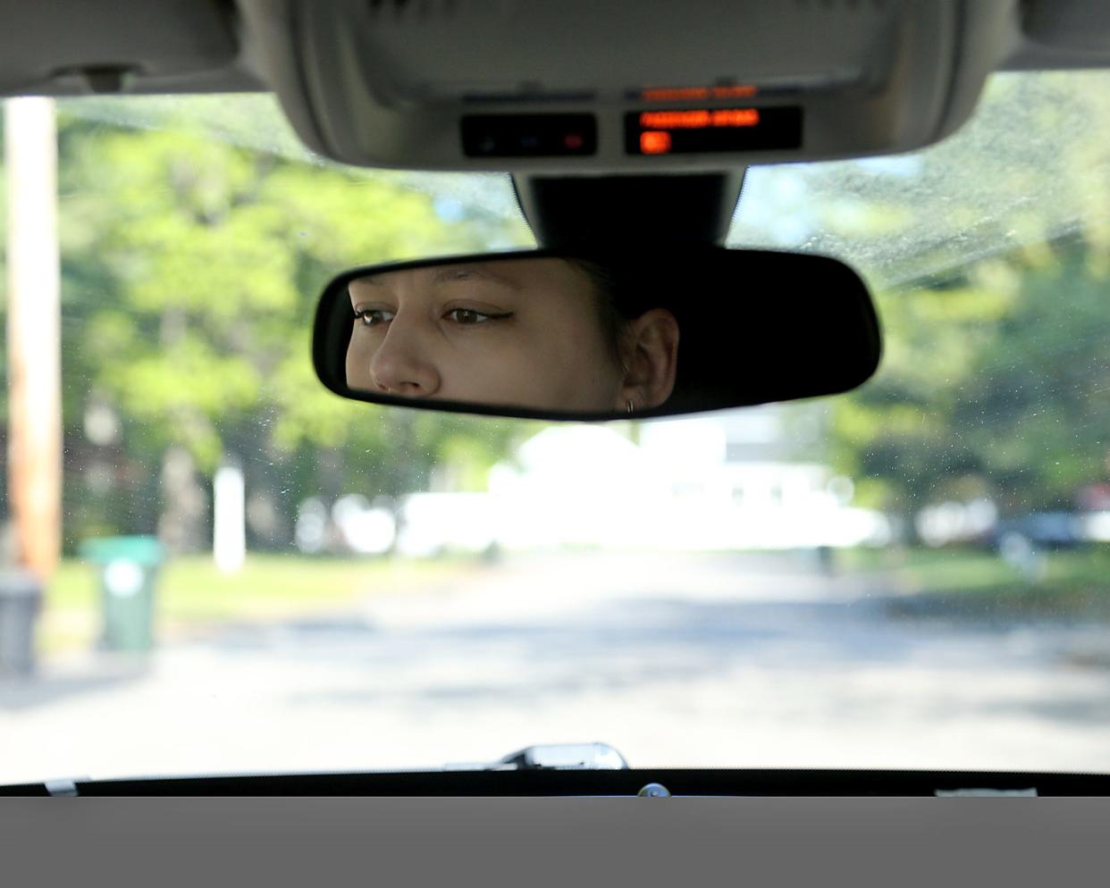 A woman is shown in a rear view mirror. A program aimed at preventing children from being hit by vehicles encourages drivers to "spot the tot" before backing up.