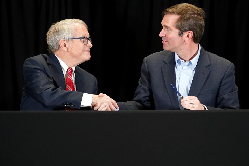 Ohio Gov. Mike DeWine, left, and Kentucky Gov. Andy Beshear on Feb. 28 sign a memorandum of understanding outlining their states' respective roles in the Brent Spence Bridge project.