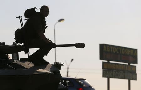 A Russian serviceman sits atop an armoured vehicle outside Kamensk-Shakhtinsky, Rostov Region, August 15, 2014. REUTERS/Maxim Shemetov