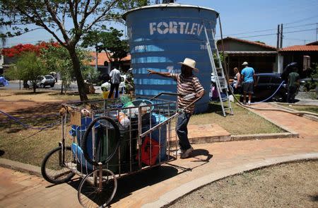 A resident of the region of Sao Paulo state that depends on the Cantareira water system, pushes a cart with containers to fill from a water tank as the eight-month rationing of water continues as a result of a record drought, in Itu, October 28, 2014. REUTERS/Nacho Doce