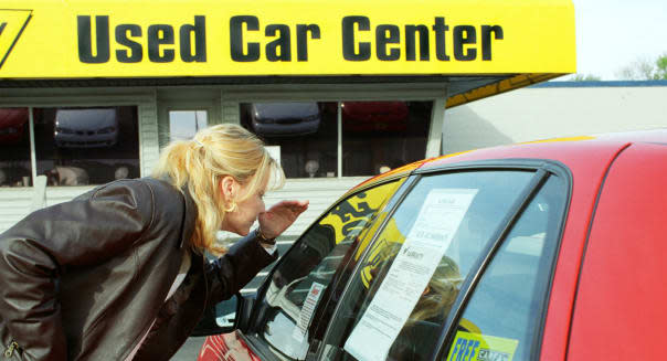 AMTD88 College age female shops for a used automobile and looks at the sticker price of the car on a used car lot College; age;