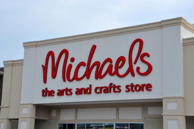 A sign is posted on the exterior of a Michaels art and crafts