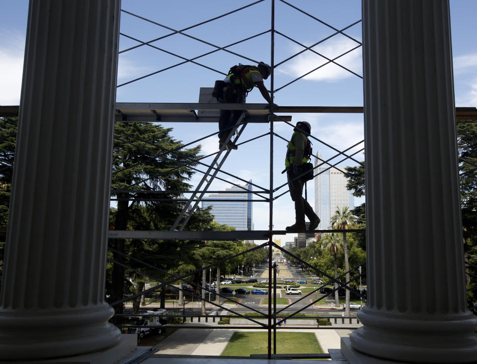 FILE - In this July 25, 2019, file photo workers assemble scaffolding on the west side of the state Capitol in preparation for a routine maintenance project, in Sacramento, Calif. Yields on 2-year and 10-year Treasury notes inverted early Wednesday, Aug. 14, a market phenomenon that shows investors want more in return for short-term government bonds than they do for long-term bonds. It's the first time that has happened since the Great Recession and it can be a sign that investors have lost faith in the soundness of the U.S. economy. (AP Photo/Rich Pedroncelli, File)