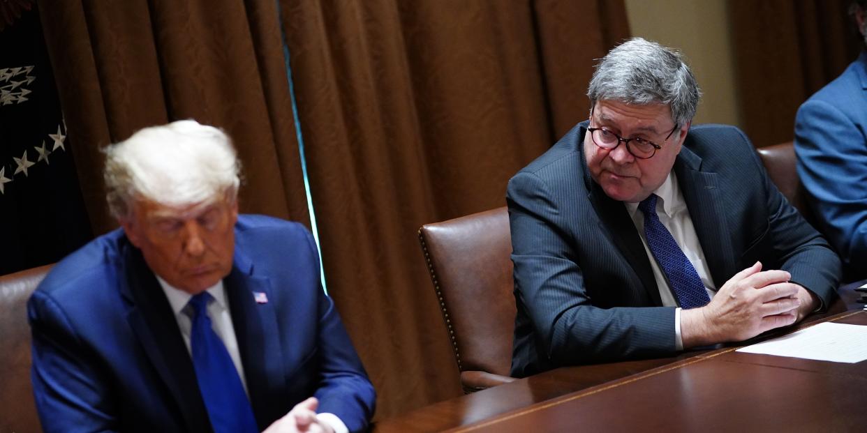 Donald Trump and William Barr sit next to each other.