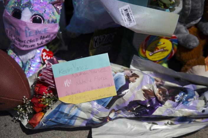 Heartfelt notes, flowers, candles and a football left by residents at a memorial.