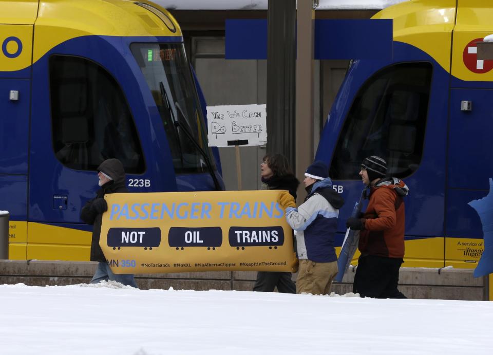 Climate change activists rallied outside the Union Depot in St. Paul, Minn., Wednesday, Feb. 26, 2014 prior to the visit of President Barack Obama. They urged Obama to reject the proposed Keystone XL oil pipeline from Canada to the Gulf Coast and say oil trains from North Dakota are disrupting Amtrak traffic. (AP Photo/Jim Mone)