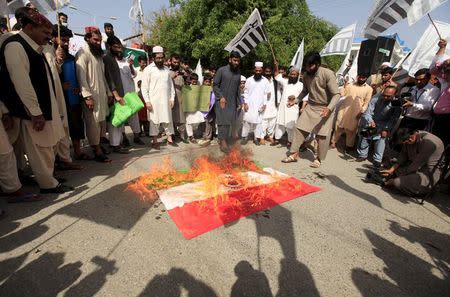 Supporters of the Jamaat-ud-Dawa organization burn an Indian flag during a demonstration in Islamabad April 17, 2015. REUTERS/Faisal Mahmood