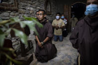 Seminarist Oveniel Garcia, 21, left, kneels during a Mass celebrated by Friar Leopoldo Serrano in the chapel at Mission San Francisco de Asis, Honduras, Saturday, June 19, 2021. Garcia, a former drug addict and trafficker, entered the rehab center at the mission run by Serrano. Over the years, he became Serrano’s right-hand man. (AP Photo/Rodrigo Abd)