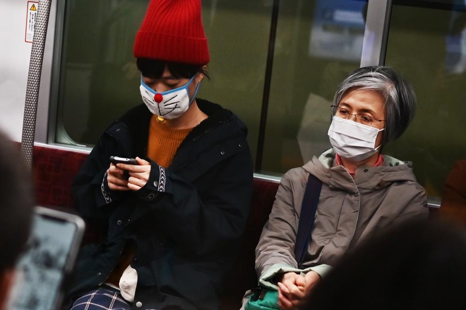 People wearing face masks travel on a train in Tokyo.