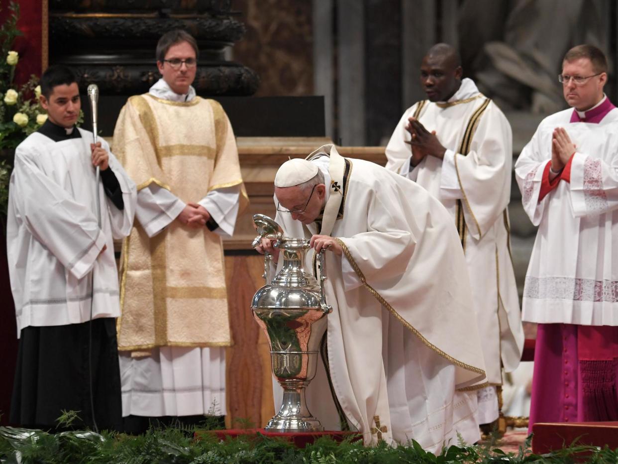 Pope Francis blows in an amphora containing holy oil during the Holy Chrism Mass on Maundy Thursday at St Peter's basilica in the Vatican on 29 March 2018: Getty Images