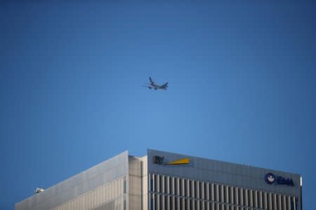 FILE PHOTO: An aircract flies over The European Medecines Agency and Ernst and Young's building in Canary Wharf on a clear morning in London, Britain, August 8, 2018. REUTERS/Hannah McKay/File Photo