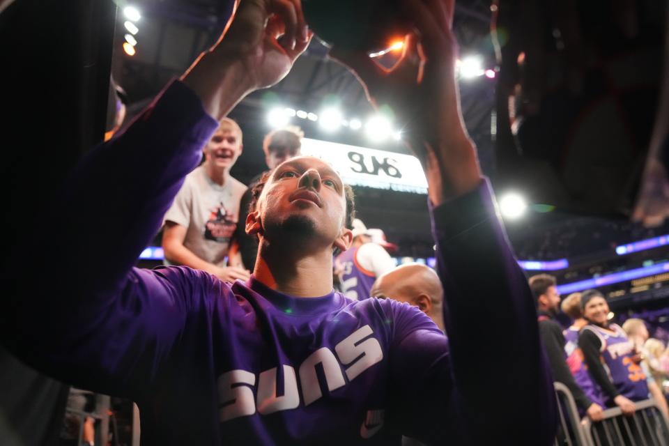 Phoenix Suns guard Landry Shamet (14) signs autographs for fans after the team's 100-93 win over the Denver Nuggets at Footprint Center in Phoenix on March 31, 2023.