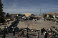 <p>People walk next to a destroyed house after an earthquake, in the city of Darbandikhan, northern Iraq, Nov. 13, 2017. (Photo: Felipe Dana/AP) </p>