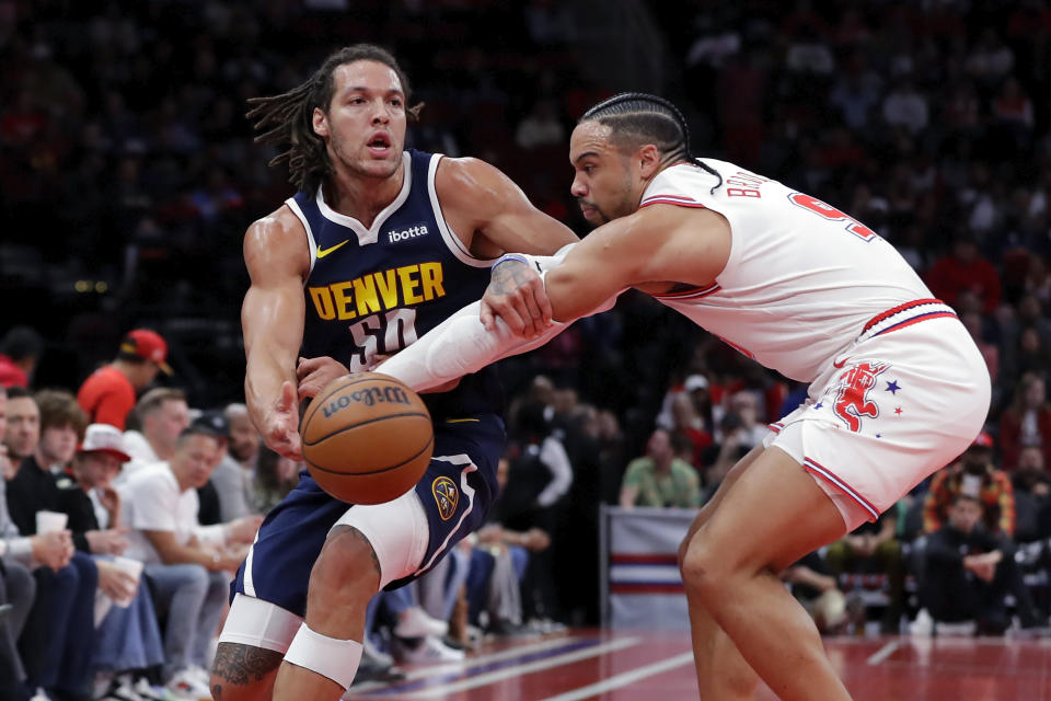 Denver Nuggets forward Aaron Gordon, left, passes the ball as Houston Rockets forward Dillon Brooks, right, reaches in during the first half of an NBA basketball In-Season Tournament game Friday, Nov. 24, 2023, in Houston. (AP Photo/Michael Wyke)