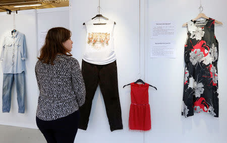 A woman watches clothes at the exhibition "What Were You Wearing?" that showcases the stories of U.S. student rape victims through representations of the outfits they wore during their assault, in the Brussels district of Molenbeek, Belgium January 16, 2018. REUTERS/Francois Lenoir