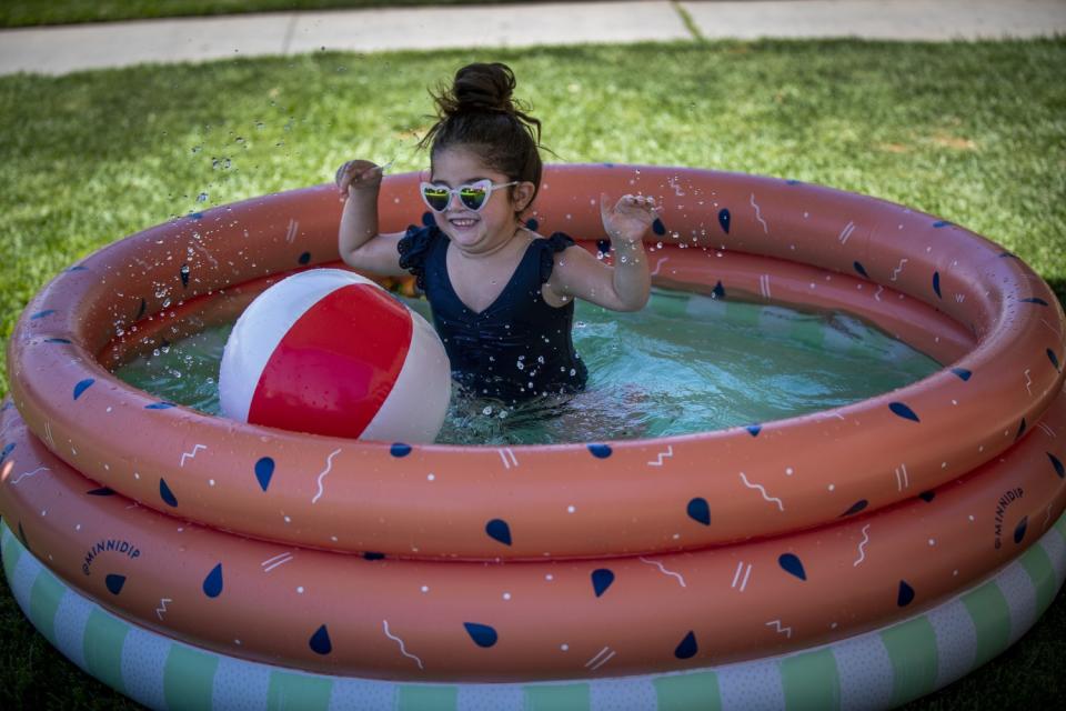 Child plays in a kiddie pool in front of her Whittier apartment