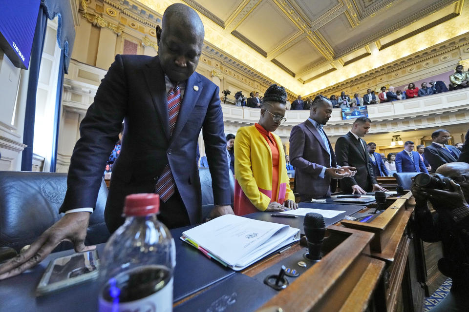 FILE - New Virginia House of Delegates speaker, Del. Don Scott, D-Portsmouth, left, listens to the morning prayer along with Del. Jackie Glass, D-Norfolk, second from left, Del. Ladarius Clark, D-Suffolk, second from right, and Del. Sam Rasoul, D-Roanoke, right, during the opening of the 2024 session of the Virginia General Assembly at the Capitol Wednesday Jan. 10, 2024, in Richmond, Va. Dozens of pieces of gun-related legislation that advocates say will bolster public safety are winding their way through Virginia’s Democratic-controlled General Assembly, including a measure that would halt the sale of certain semi-automatic rifles and pistols. The question hanging over all the bills is: Just how many will Republican Gov. Glenn Youngkin veto? (AP Photo/Steve Helber, File)