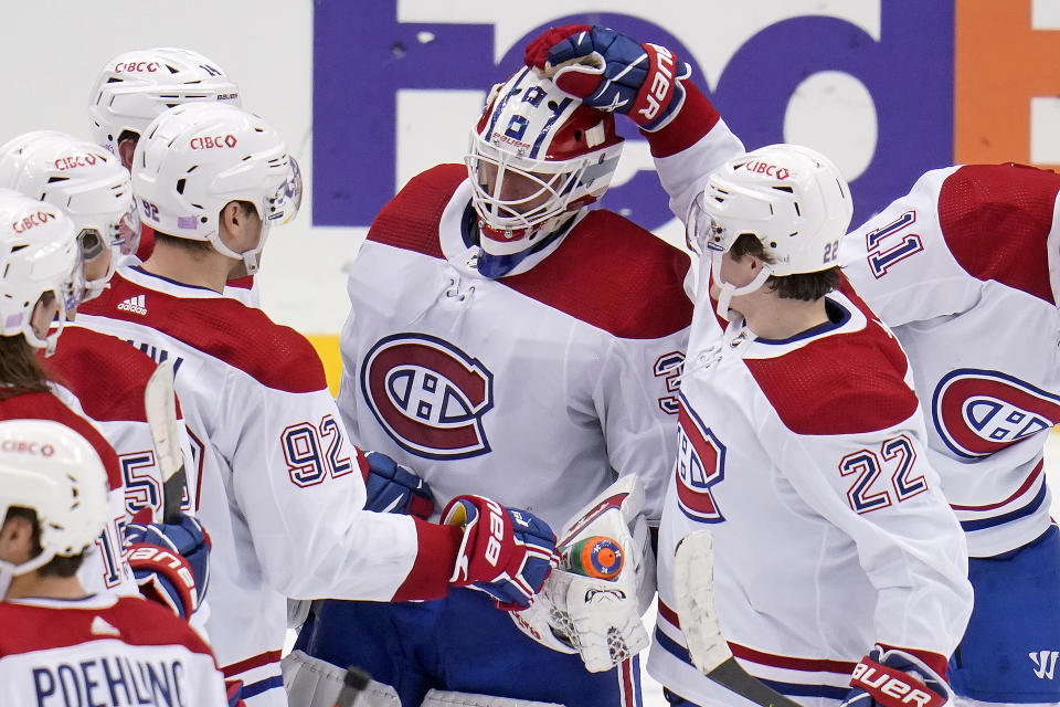 Montreal Canadiens goaltender Jake Allen, center, celebrates with teammates after a win over the Pittsburgh Penguins in an NHL hockey game in Pittsburgh, Saturday, Nov. 27, 2021. (AP Photo/Gene J. Puskar)