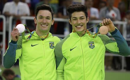 2016 Rio Olympics - Artistic Gymnastics - Victory Ceremony - Men's Floor Victory Ceremony - Rio Olympic Arena - Rio de Janeiro, Brazil - 14/08/2016. Diego Hypolito (BRA) of Brazil and Arthur Mariano (BRA) of Brazil pose with their medals. REUTERS/Mike Blake