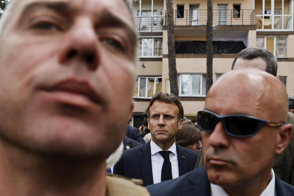 Surrounded by a security detail, French President Emmanuel Macron, center, visits Irpin, on the outskirts of Kyiv, Thursday, June 16, 2022. The leaders of France, Germany, Italy and Romania arrived in Kyiv on Thursday in a show of collective European support for the Ukrainian people as they resist Russia's invasion, marking the highest-profile visit to Ukraine's capital since Russia invaded its neighbor. (Ludovic Marin, Pool via AP)