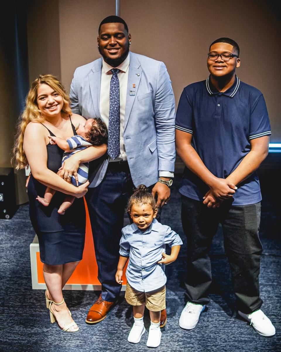 Former Auburn and University of Illinois offensive tackle Vederian Lowe, center, in tie, poses with his family two years ago: (from left) wife Haylee, holding son Trey, next to their other son Kingston, with Lowe's brother Vydalis Cockrell. Lowe was drafted by the Vikings last spring.