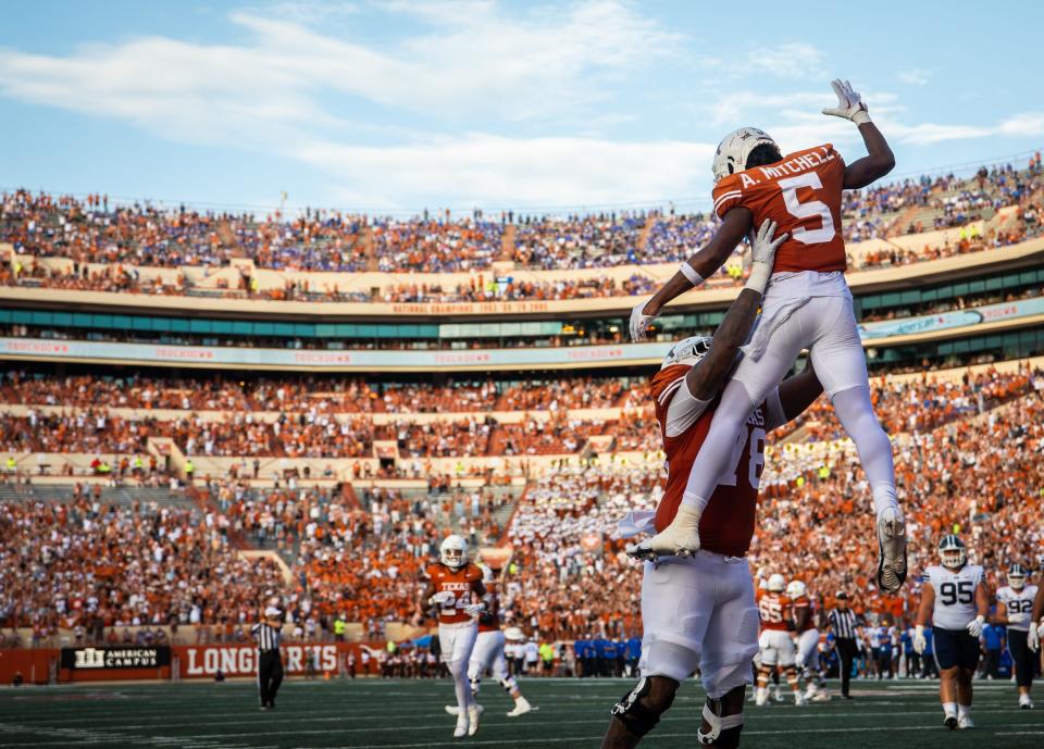 Texas left tackle Kelvin Banks Jr. lifts wide receiver Adonai Mitchell after his second touchdown catch in the fourth quarter of Saturday's 35-6 win over BYU at Royal-Memorial Stadium. The Longhorns improved to 7-1 and, with Oklahoma's loss at Kansas, are tied for first in the Big 12.