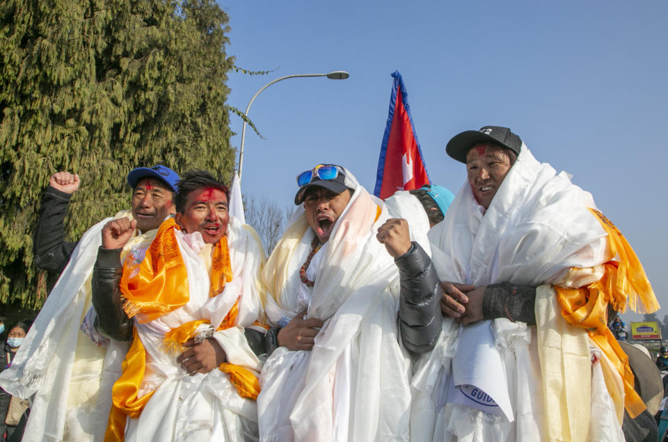 The all-Nepalese mountaineering team that became the first to scale Mount K2 in winter cheer as they arrive at Tribhuwan International airport in Kathmandu, Nepal, Tuesday, Jan. 26, 2021. (AP Photo/Niranjan Shrestha)