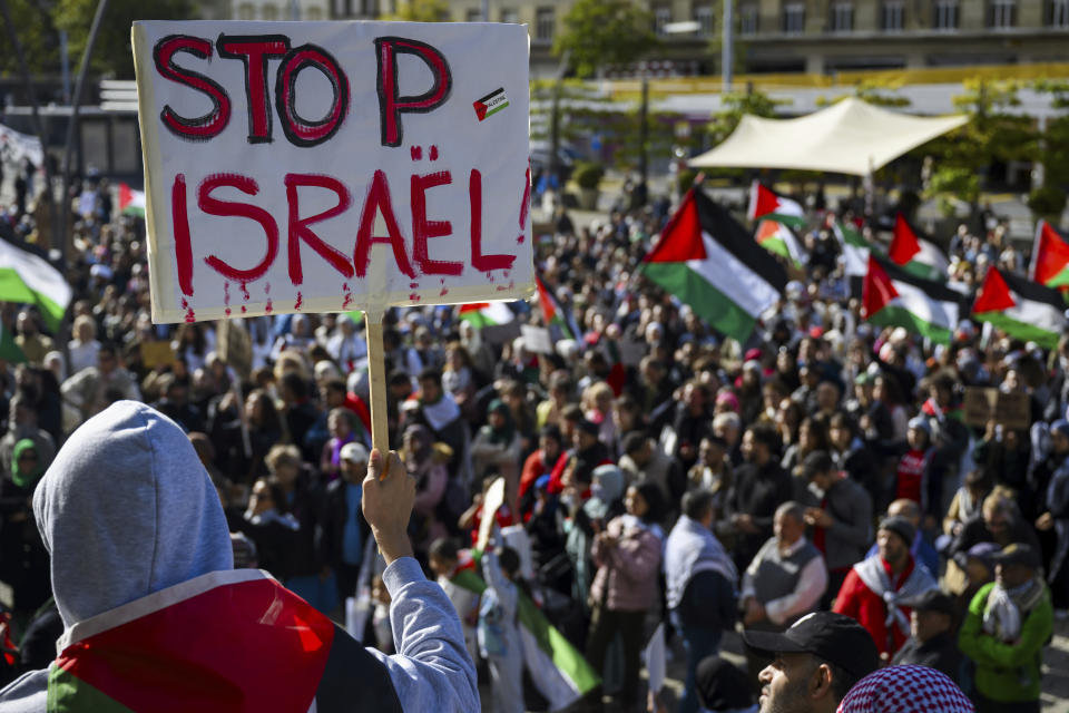 Protesters hold placards and Palestinian flags during a pro-Palestinian rally, in Lausanne, Switzerland, Saturday, Oct. 21, 2023. (Jean-Christophe Bott/Keystone via AP)
