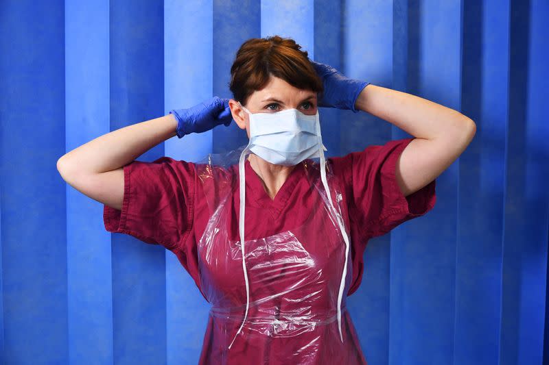 Doctor Nicky Longley puts on her Level 1 PPE at a hospital in London