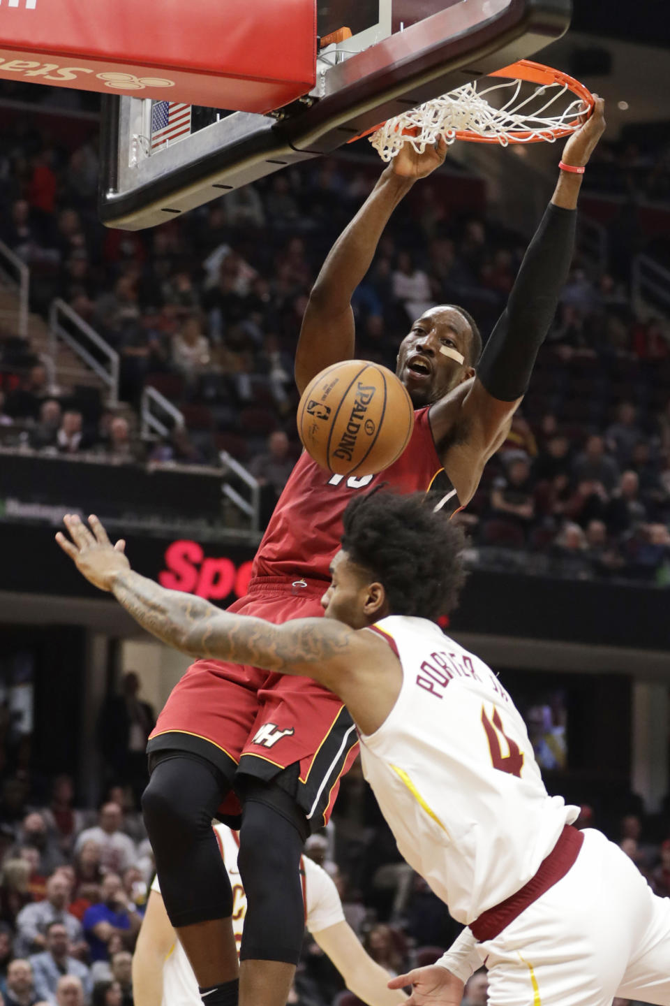 Miami Heat's Bam Adebayo, top, dunks against Cleveland Cavaliers' Kevin Porter Jr. (4) in the second half of an NBA basketball game, Monday, Feb. 24, 2020, in Cleveland. (AP Photo/Tony Dejak)