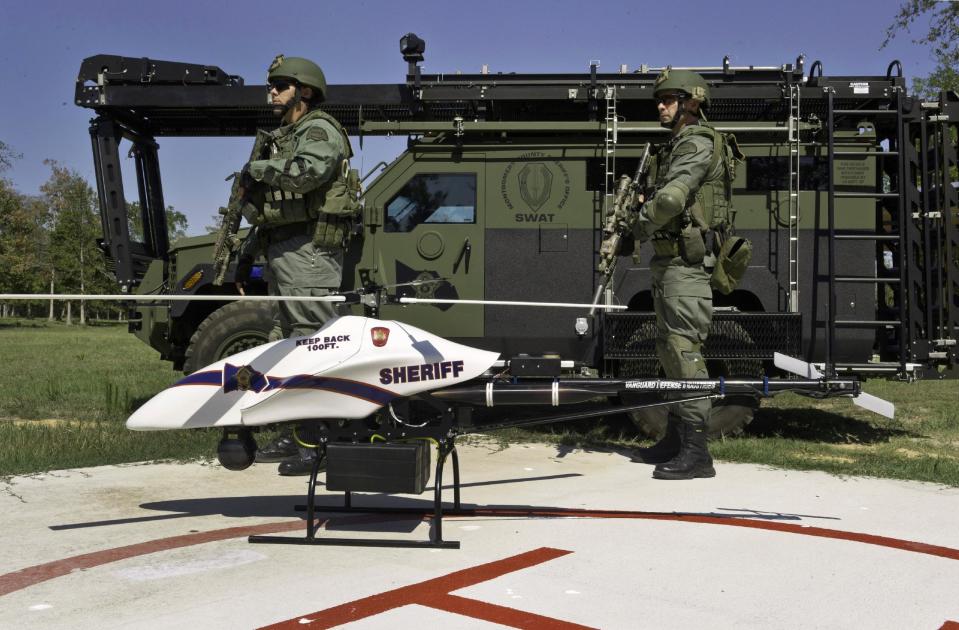 This Sept. 2011 photo provided by Vanguard Defense Industries, shows a ShadowHawk drone with Montgomery County, Texas, SWAT team members. Civilian cousins of the unmanned military aircraft that have been tracking and killing terrorists in the Middle East and Asia are being sought by police departments, border patrols, power companies, news organizations and others who want a bird’s-eye view. (AP Photo/Lance Bertolino, Vanguard Defense Industries)