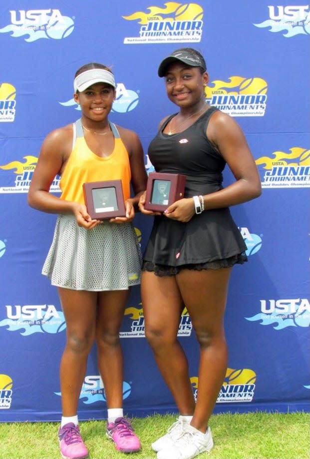 Carmen (left) and Ivana (right) Corley pose with their awards following a USTA Junior Tournament.