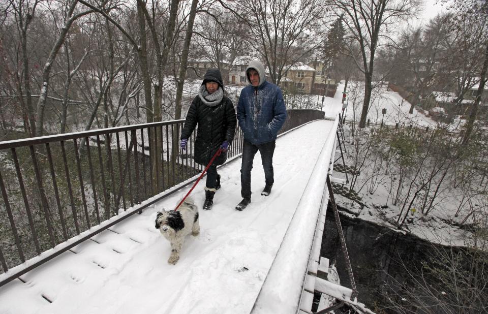 Barb Nei and Neil Holman walk their dog in Minneapolis, November 10, 2014. An arctic blast began to dump heavy snow in parts of the northern Rockies, Plains and the Great Lakes regions on Monday and meteorologists said temperatures are expected to plummet throughout the United States. (REUTERS/Eric Miller)