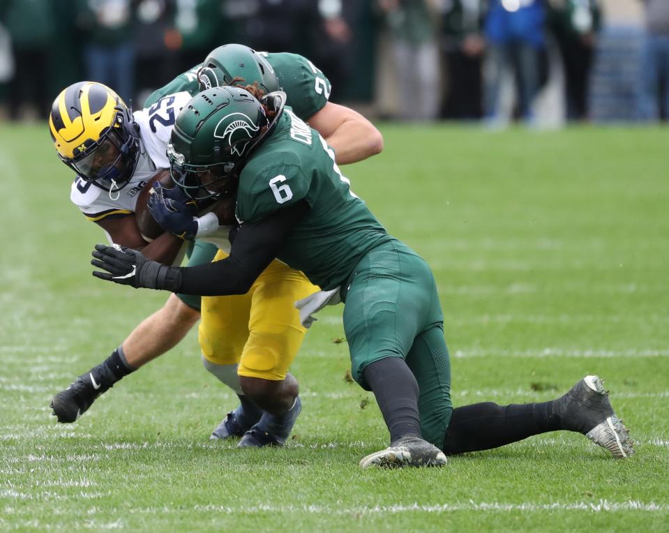 Michigan State Spartans linebacker Quavaris Crouch (6) tackles Michigan Wolverines running back Hassan Haskins (25) during the second half Saturday, Oct. 30, 2021 at Spartan Stadium in East Lansing.