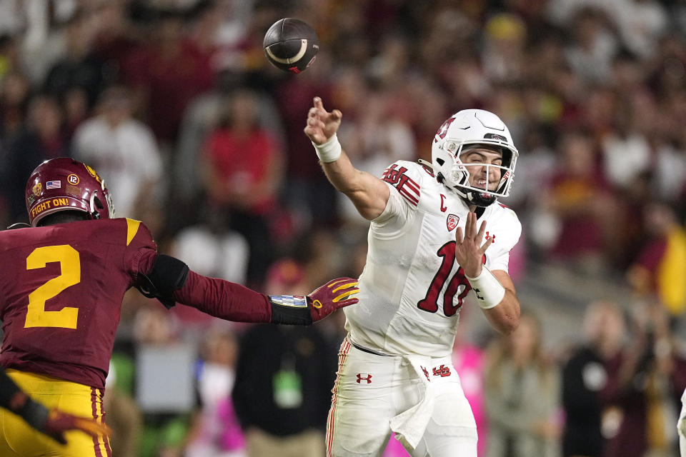 Utah quarterback Bryson Barnes, right, passes as Southern California defensive end Romello Height defends during the second half of an NCAA college football game Saturday, Oct. 21, 2023, in Los Angeles. (AP Photo/Mark J. Terrill)