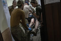 Paramedics treat a Ukrainian injured serviceman in the Donetsk region, eastern Ukraine, Tuesday, June 7, 2022. (AP Photo/Bernat Armangue)